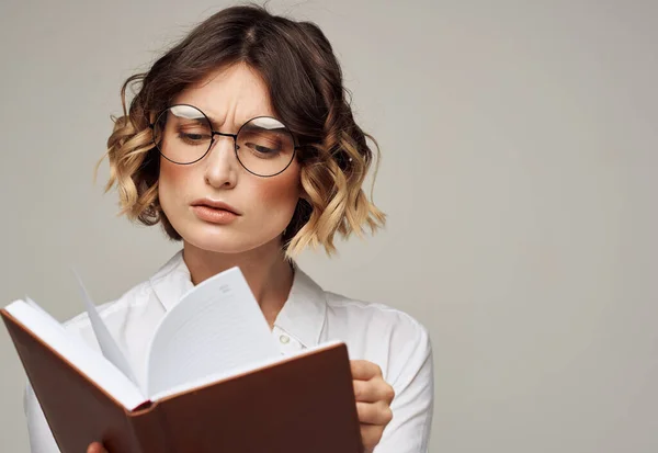 Geletterde vrouw met boek in handen en in bril wit shirt onderwijs model — Stockfoto