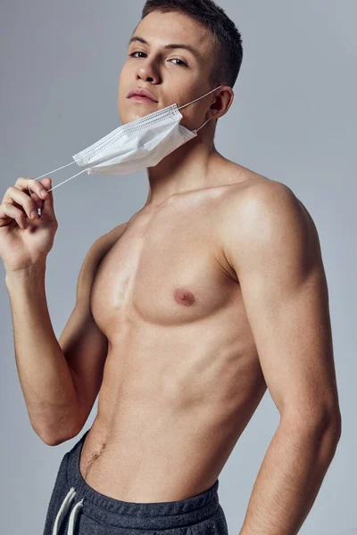Uomo sportivo con spalle nude salute medica maschera palestra primo piano — Foto Stock