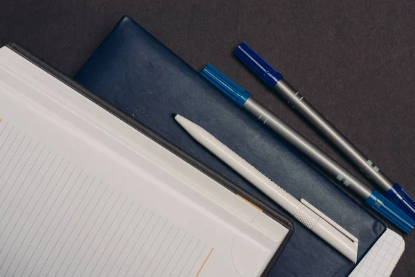 notepads documents books pens desktop gray background