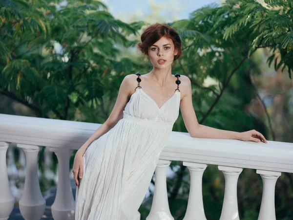 Красивая женщина в белом платье, украшающее зеленые листья — стоковое фото