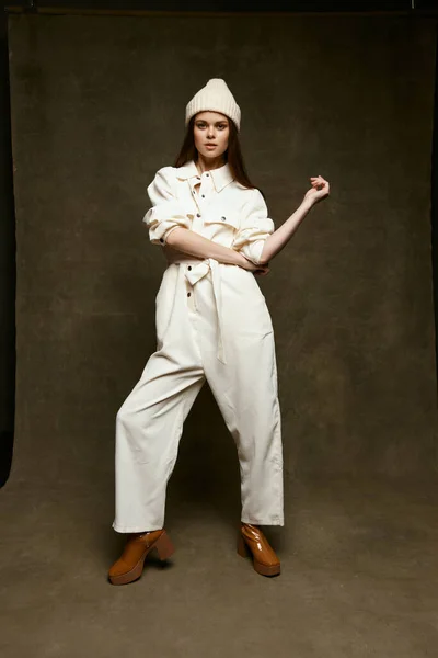 Mujer fuerte en un sombrero blanco y en un traje de luz sobre un fondo marrón gestos con las manos Copiar espacio —  Fotos de Stock