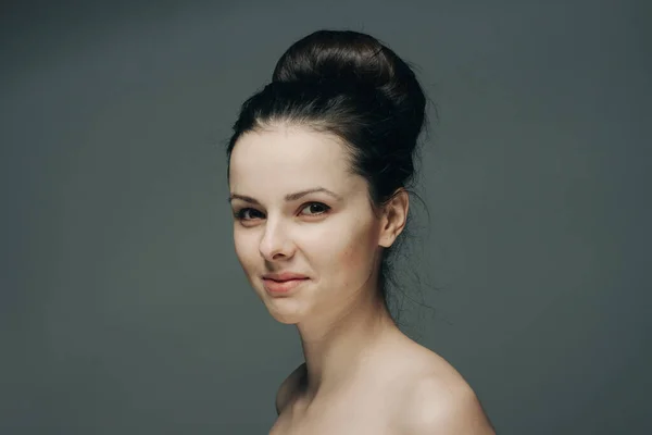 Όμορφη γυναίκα χαμογελώντας σε γκρι φόντο γυμνοί ώμοι περικοπή άποψη χτένισμα — Φωτογραφία Αρχείου