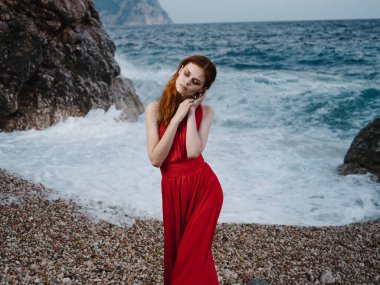 Kırmızı elbiseli kadın deniz dalgaları plaj manzarası