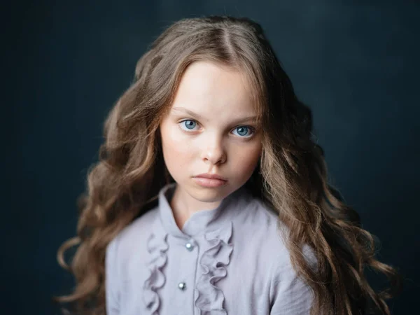 Kék ruhás lány sötét háttérrel és göndör hajjal — Stock Fotó