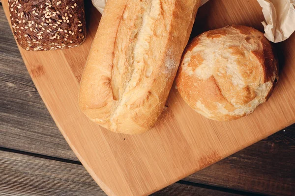 Un ürünleri somun ekmek ve ahşap arkaplan ışığı — Stok fotoğraf