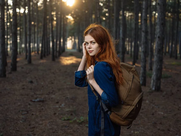 Aktivní žena turistka s batohem v lese s vysokými borovicemi v přírodě — Stock fotografie