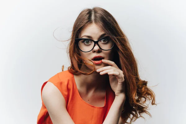 Retrato de uma mulher enérgica em um vestido de laranja e óculos no rosto emoções estudantis — Fotografia de Stock