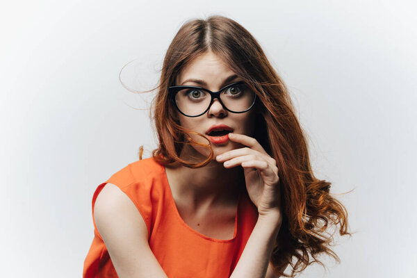 portrait of an energetic woman in an orange sundress and glasses on the face student emotions
