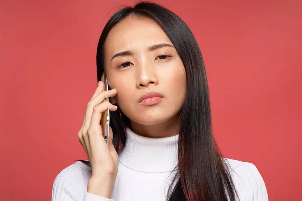 빨간 배경의 전화 기술에 대해 얘기하는 아시아 여성 — 스톡 사진