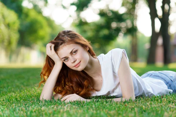 Frau liegt auf dem Gras im Park — Stockfoto