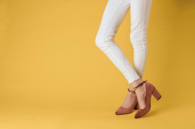 Kadın ayakları şık ayakkabılar lüks sarı arka plan zarif bir tarz.