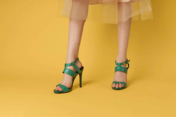 Pernas femininas sapatos verdes estilo de vida elegante fundo amarelo — Fotografia de Stock