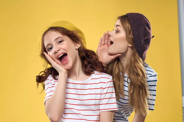 funny mom and daughter wearing hats fashion fun joy family yellow background