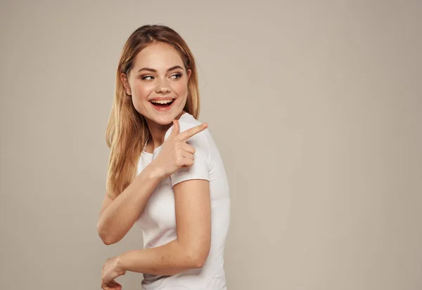 Bela loira em uma camiseta branca em um fundo cinza retrato espaço de cópia — Fotografia de Stock
