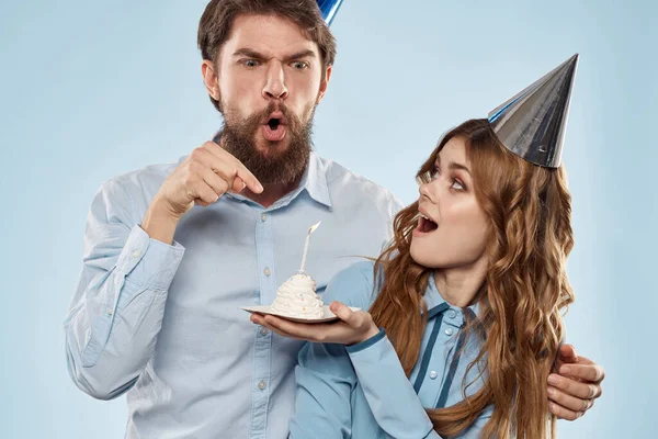 Веселые мужчина и женщина с тортом в тарелке корпоративной партии синий фон — стоковое фото