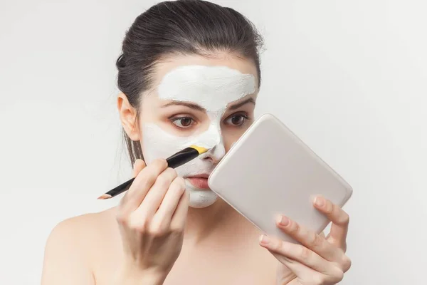 Mujer con hombros desnudos con un cepillo en las manos aplicando maquillaje —  Fotos de Stock