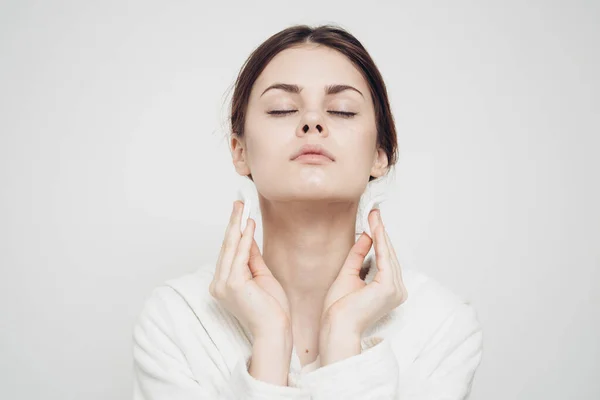 Woman in light clothes wipes her face with a soft sponge clean skin cosmetology — Stock Photo, Image