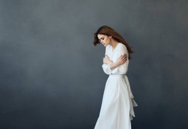 Beyaz elbiseli çekici kadın dans performansı cazibesi gri arka plan modeli