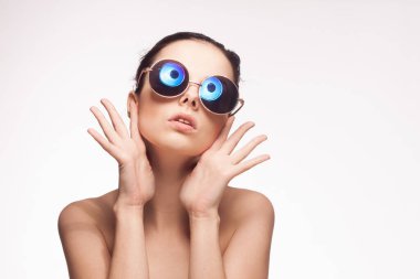 Güneş gözlüklü, çıplak omuzlu bir kadın.