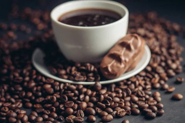 Filiżankę kawy i batonik czekoladowy na talerzu napój odmiany fasoli arabskiej — Zdjęcie stockowe