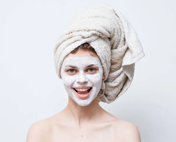 Donna con asciugamano sulla maschera crema testa spalle nude cura della pelle — Foto Stock
