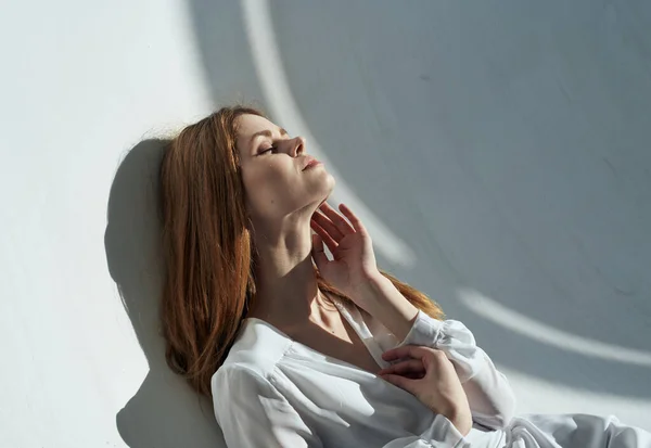 Mulher em um fundo leve em roupas brancas maquiagem cabelo vermelho — Fotografia de Stock
