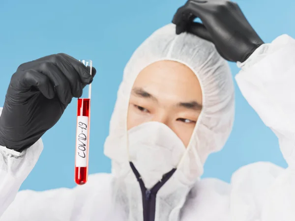 Чоловічий лабораторний асистент азіатського вигляду чорні рукавички Аналіз крові коронавірусу — стокове фото