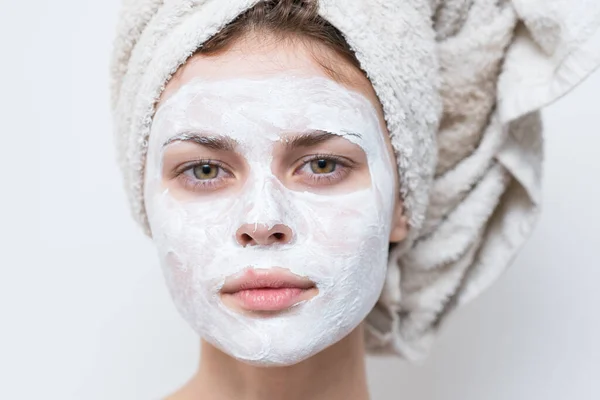 Bonita mujer con toalla en la cabeza máscara de crema en la cara de cerca —  Fotos de Stock