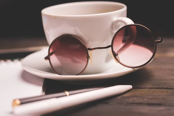 Taza de café en un platillo de madera bloc de notas pluma oficina papelería —  Fotos de Stock