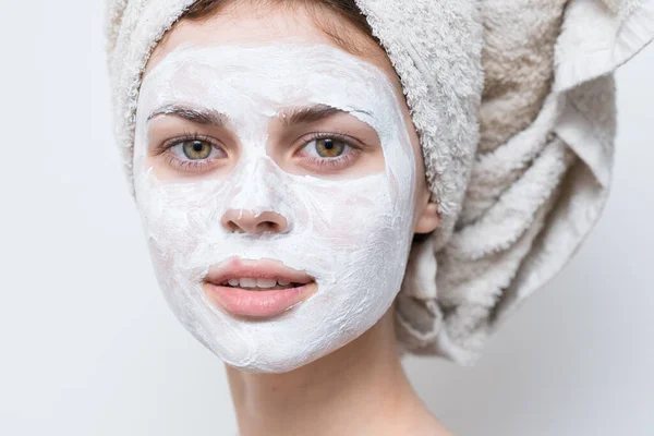 Femme avec de la crème sur son visage serviette sur sa tête soins de la peau gros plan — Photo