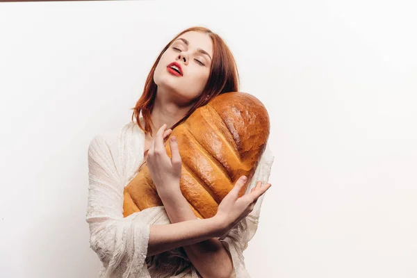 Bela mulher abraçando pão com as mãos maquiagem tecido transparente em seus ombros — Fotografia de Stock