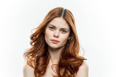 Neşeli kadın çekici görünüyor. Çıplak omuzlar. Açık renk arka plan.