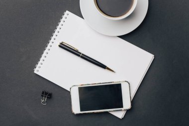 Kalem bardağı telefon teknolojisiyle birlikte çalışma masası not defteri.