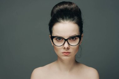 Çıplak omuzlu güzel esmer kadın portresi. Moda modelli kırpık gözlükler.