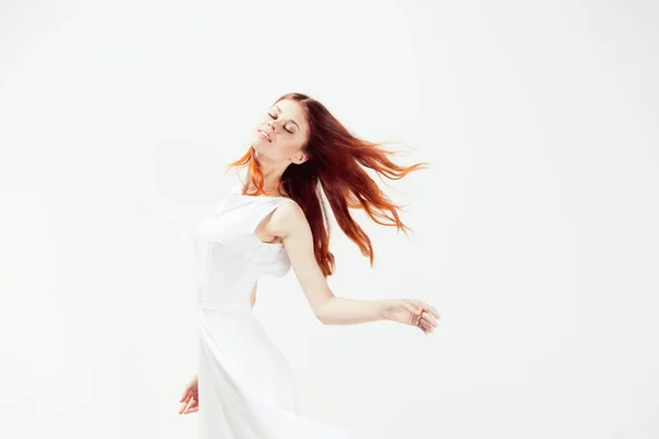 Donna in abito bianco capelli rossi movimento glamour — Foto Stock