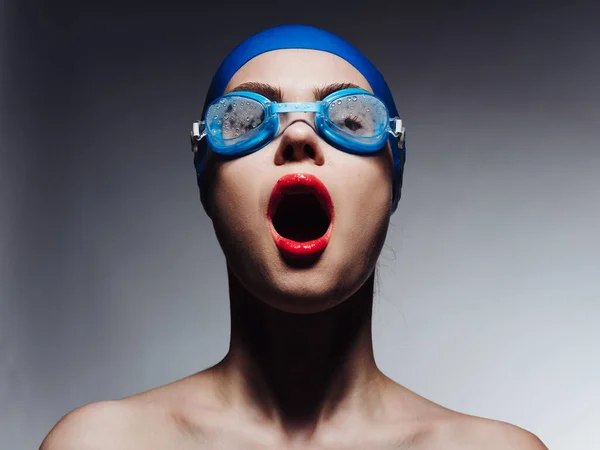 Deportista con labios rojos en gorra de natación azul y gafas mirando hacia arriba vista recortada — Foto de Stock