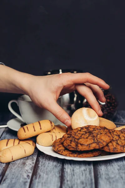 Kekse auf einem Teller, eine Tasse Tee auf einem Holztisch — Stockfoto