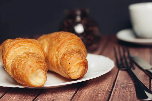 Färska croissanter på ett tefat bord dukning frukost kopp med drycker — Stockfoto