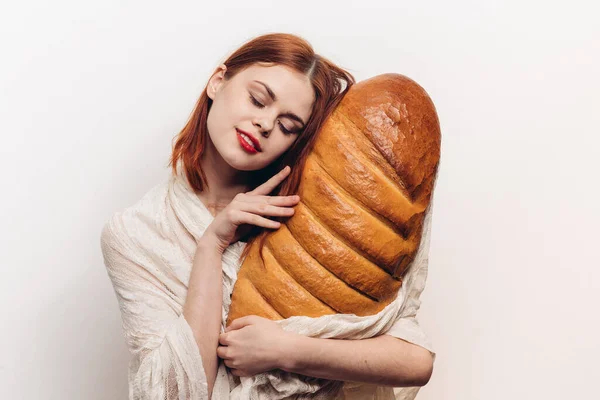 Feliz mujer pelirroja con pan en las manos sobre fondo claro vista recortada —  Fotos de Stock
