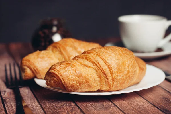 Krispiga croissanter på tallrik köksredskap till frukost måltid dessert — Stockfoto