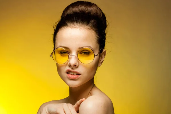 Όμορφη γυναίκα γυμνοί ώμοι κίτρινα γυαλιά συναισθήματα γοητεία κίτρινο φόντο — Φωτογραφία Αρχείου