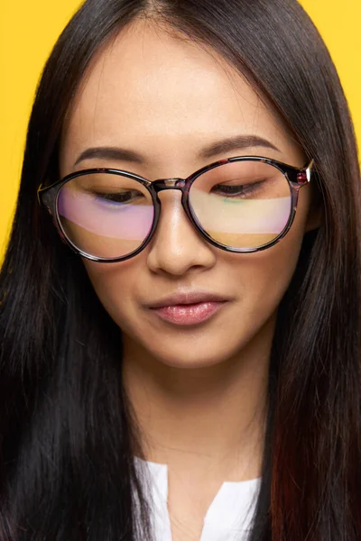 Ασιάτισσα με γυαλιά μαθήτρια γκρο πλαν κίτρινο φόντο — Φωτογραφία Αρχείου