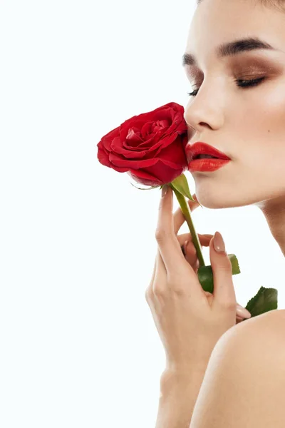 Femme romantique avec fleur rouge parfumée près du visage peau propre cosmétologie dermatologie — Photo