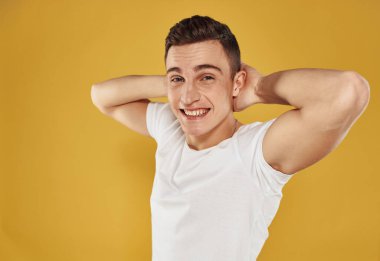 Mutlu adam elleriyle jest yapar. Eğlenceli duygular. Sarı arka plan.