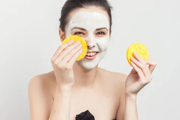 Brunette with sponges in hands cream mask scrub — Stock Photo, Image