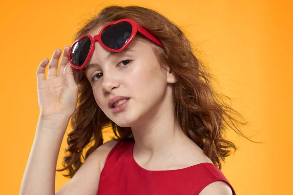 Chica en gafas negras vestido rojo infantil divertido fondo amarillo —  Fotos de Stock