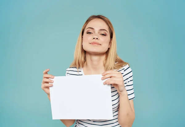 Donna bionda con un foglio di carta bianco tra le mani su uno sfondo blu banner annuncio — Foto Stock