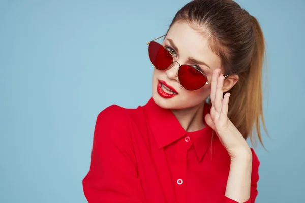 Pretty woman red shirt glamor dark glasses blue background — Stock Photo, Image