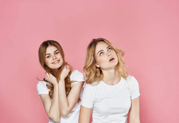 Две женщины в футболках мода гламурные эмоции общения розовый фон — стоковое фото