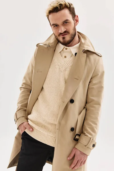 Емоційний чоловік в бежевому пальто осінній стиль моди модель студії — стокове фото